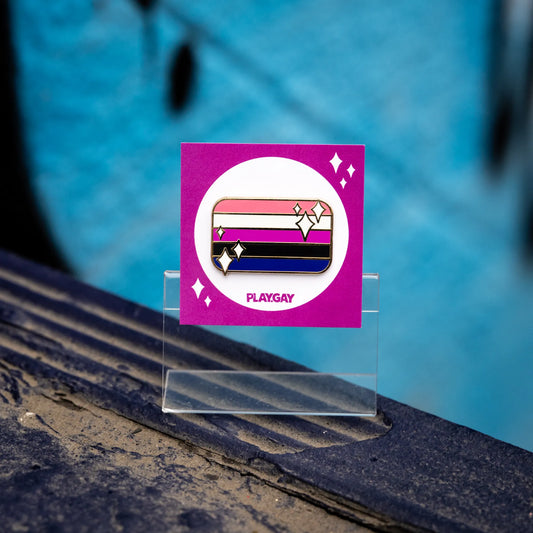 Genderfluid pride flag enamel pin with pink, white, purple, black, and blue stripes with white sparkle accents, displayed on a purple PlayGay backing card.