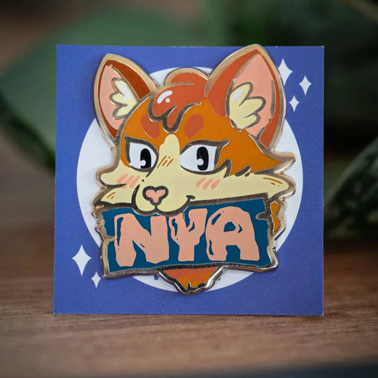 PlayGay Nya Cat (Blue) Enamel Pin – orange cat with NYA banner in teal, hard enamel on blue backing card