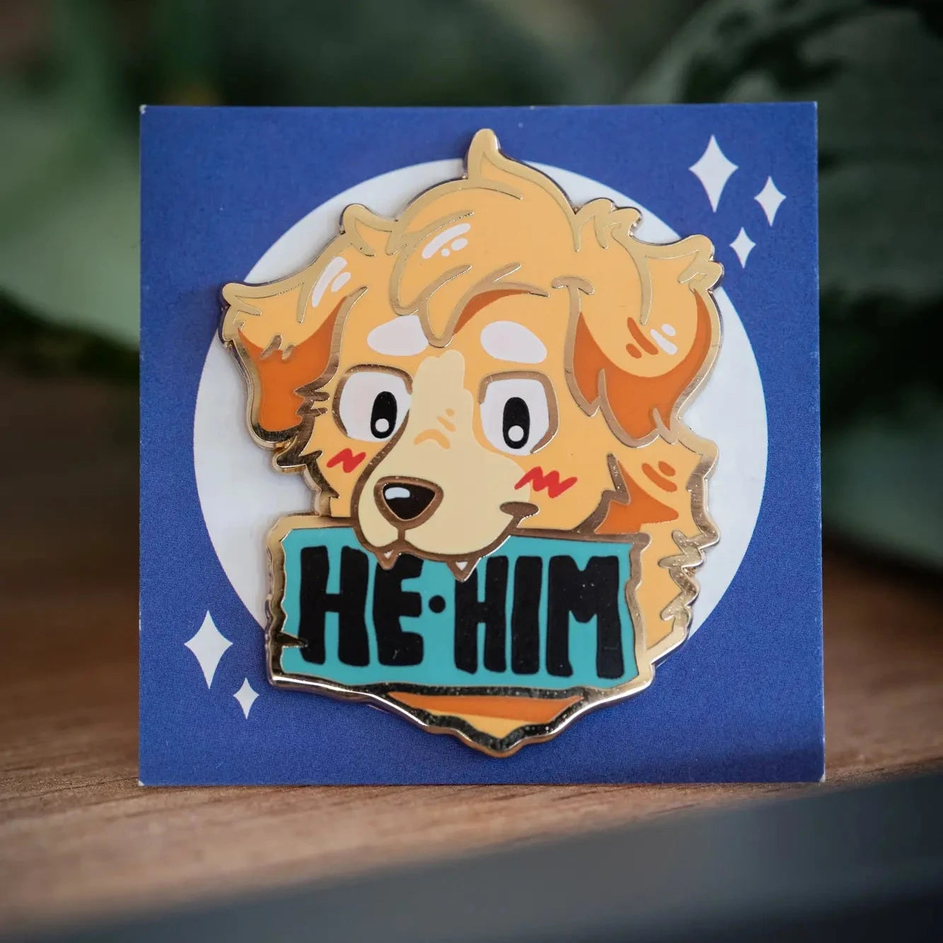PlayGay Pronoun Dogs HE·HIM Enamel Pin - golden fluffy dog with HE·HIM banner on teal, hard enamel on blue backing card